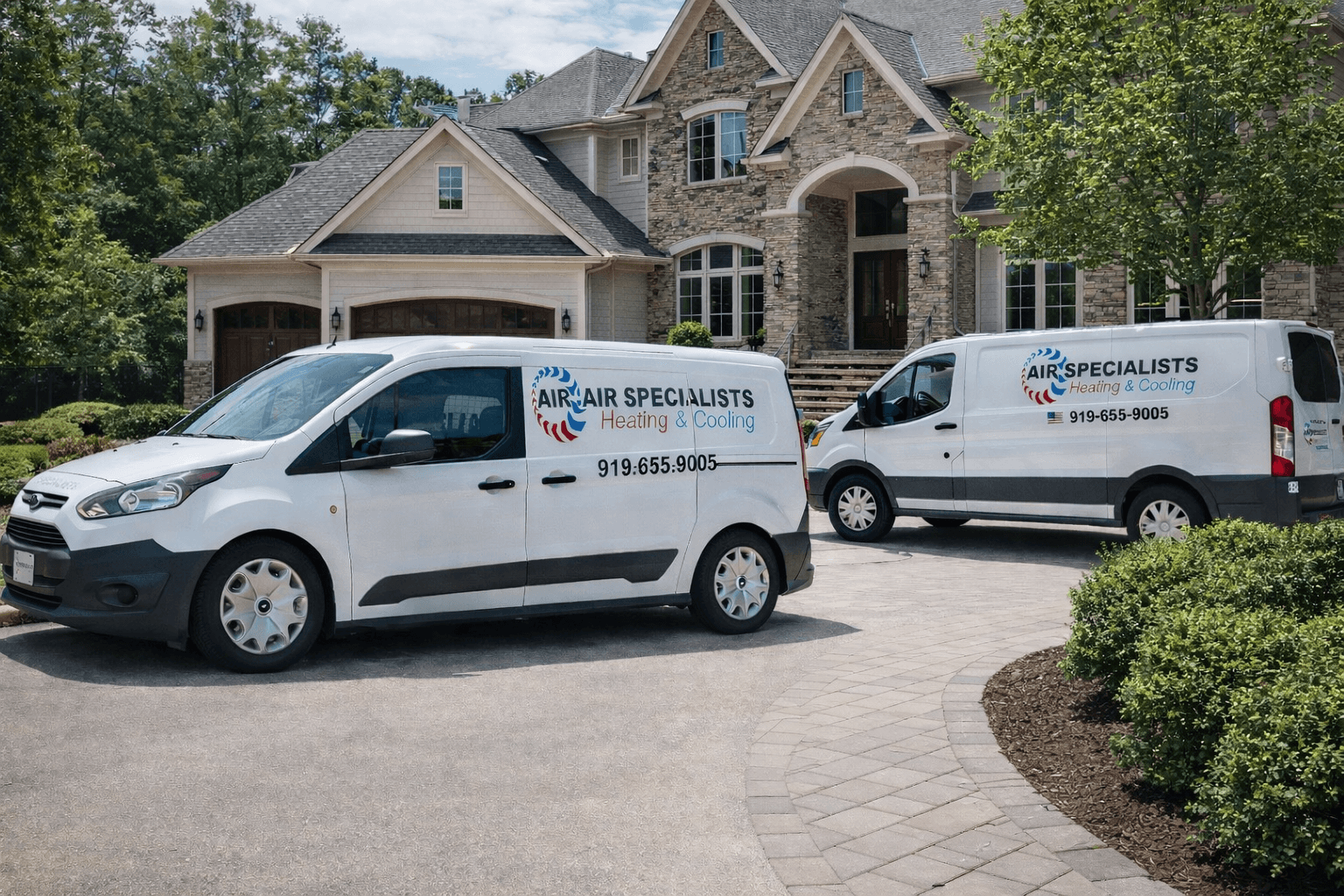 Two Air Specialists Heating & Cooling vans parked in front of a large stone home.